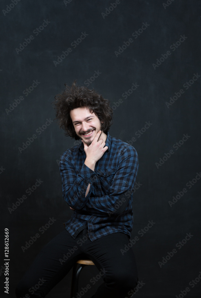 Portrait of a fashionable young man on dark background, chalkboa