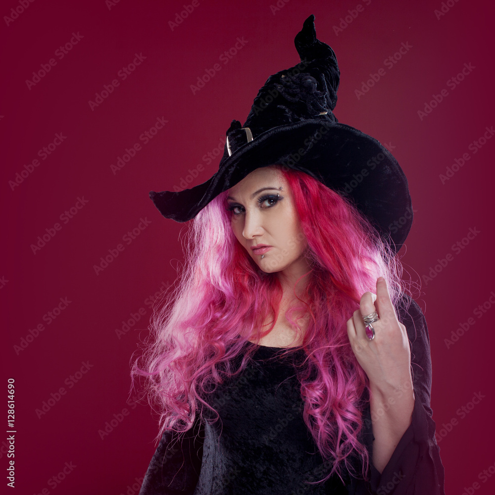 Attractive woman in witches hat and costume with red hair. Halloween Attractive woman in witches hat and costume with red hair. Halloween