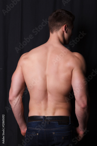 sports guy with a naked torso on a black background