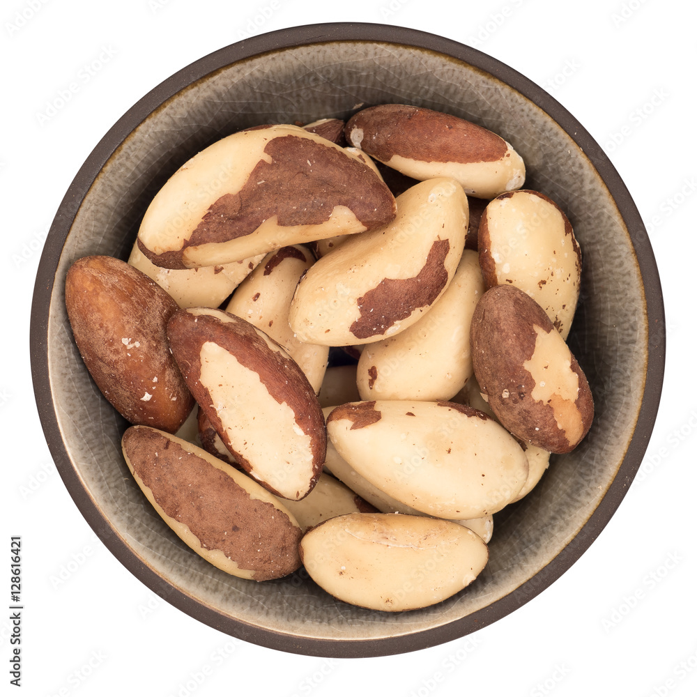 Bio organic brazil nuts in ceramic bowl isolated on white background, top view Bio organic brazil nuts in ceramic bowl isolated on white background, top view