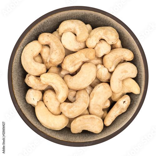 Bio organic cashews in ceramic bowl isolated on white background, top view