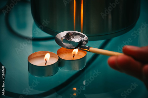 Bleigießen/Löffel mit Blei über einem Teelicht