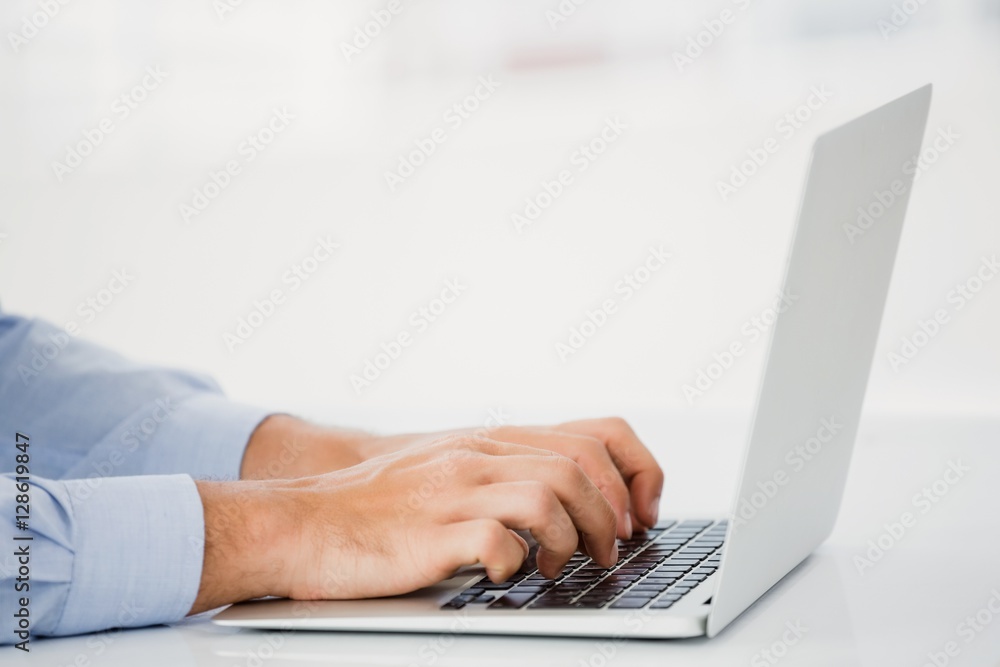 Mid-section of businessman working on laptop Mid-section of businessman working on laptop
