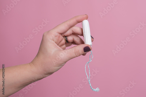 Woman's hand holding a clean cotton tampon