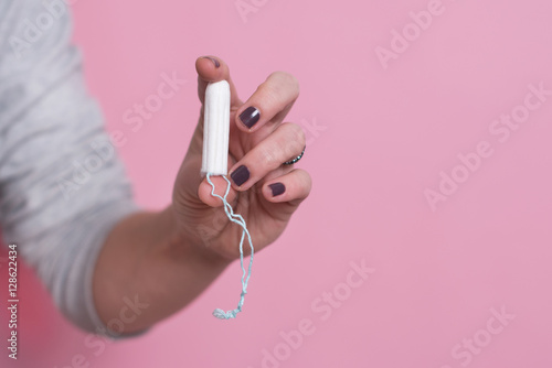 Woman's hand holding a clean cotton tampon