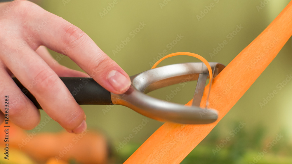 Cpose-up woman is slicing carrot