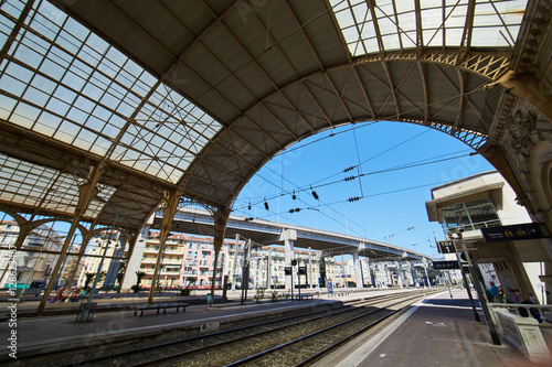 France, Nice, 15 august 2016: Panorama of the railway station in the center, sunny day, blue sky, a lot of tourists, Rails under glass a roof, in front of shaped visor, sncf, gare