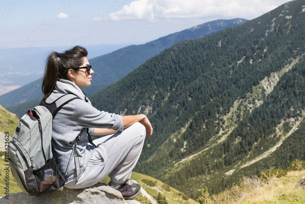 Naklejka premium woman backpacker on a mountain peak