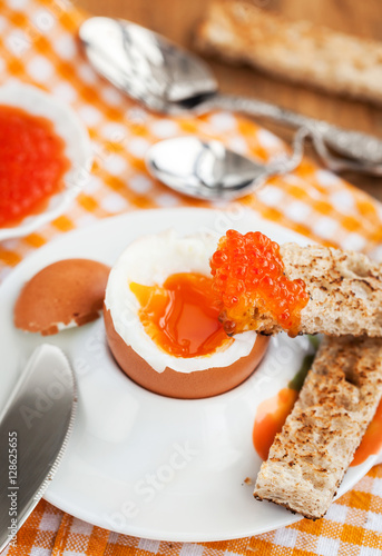 Boiled egg with red caviar, toast and coffee