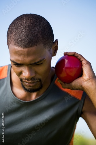 Male athlete holding shot put ball
