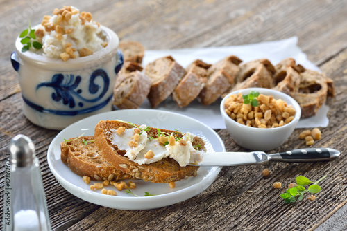 Deftiges Griebenschmalz im Schmalztopf mit rustikalem Brot serviert - Hearty lard with greaves and onions in a rustic stoneware pot served with fresh corn bread photo