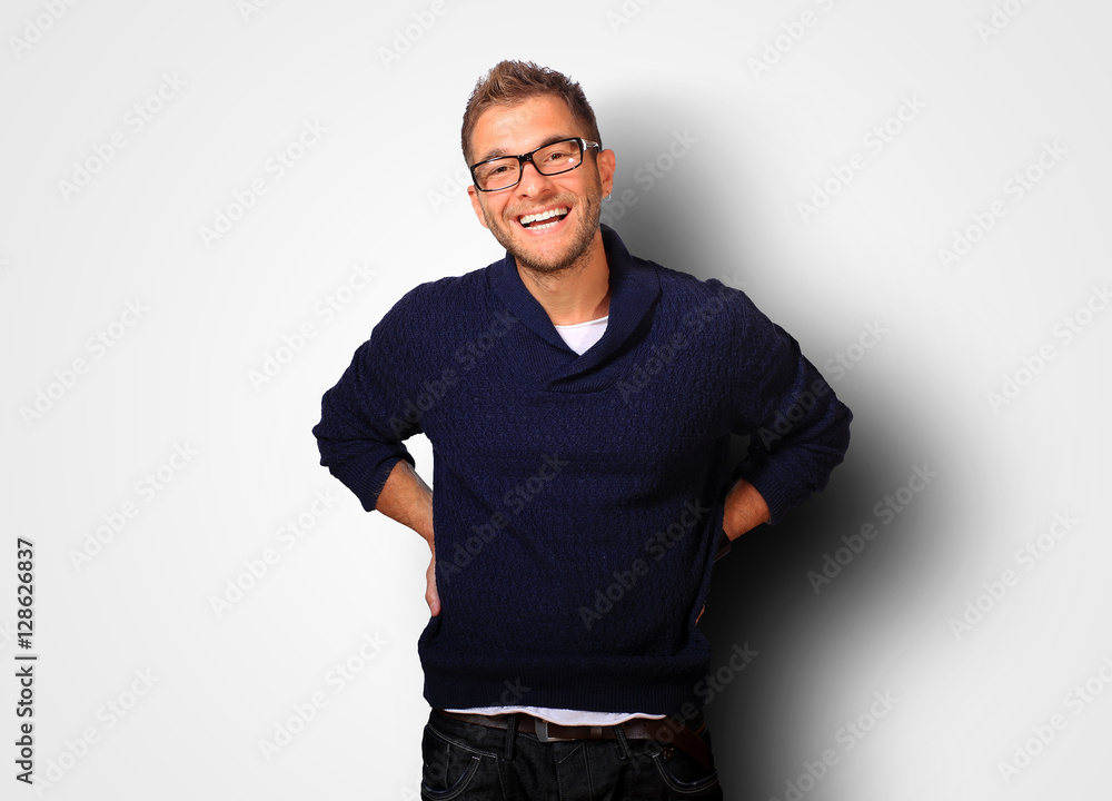 Fototapeta premium Young man in a blue sweater and jeans smiles