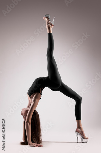 Acrobatic dancing woman posing on light background