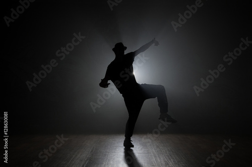 Hip-hop dancer posing backlit.