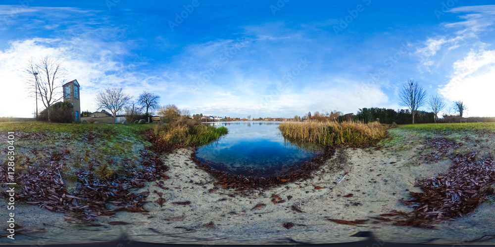 
360 degrees spherical panorama of a small lake with trees and blue sky
