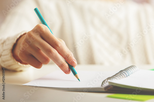 Female writing in spiral notepad
