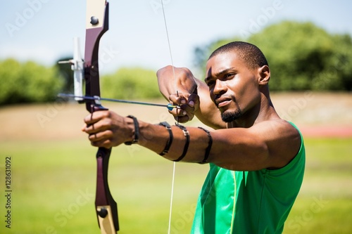 Obraz na plátně Athlete practicing archery