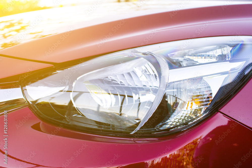 Closeup headlights of red car with sunlight Closeup headlights of red car with sunlight
