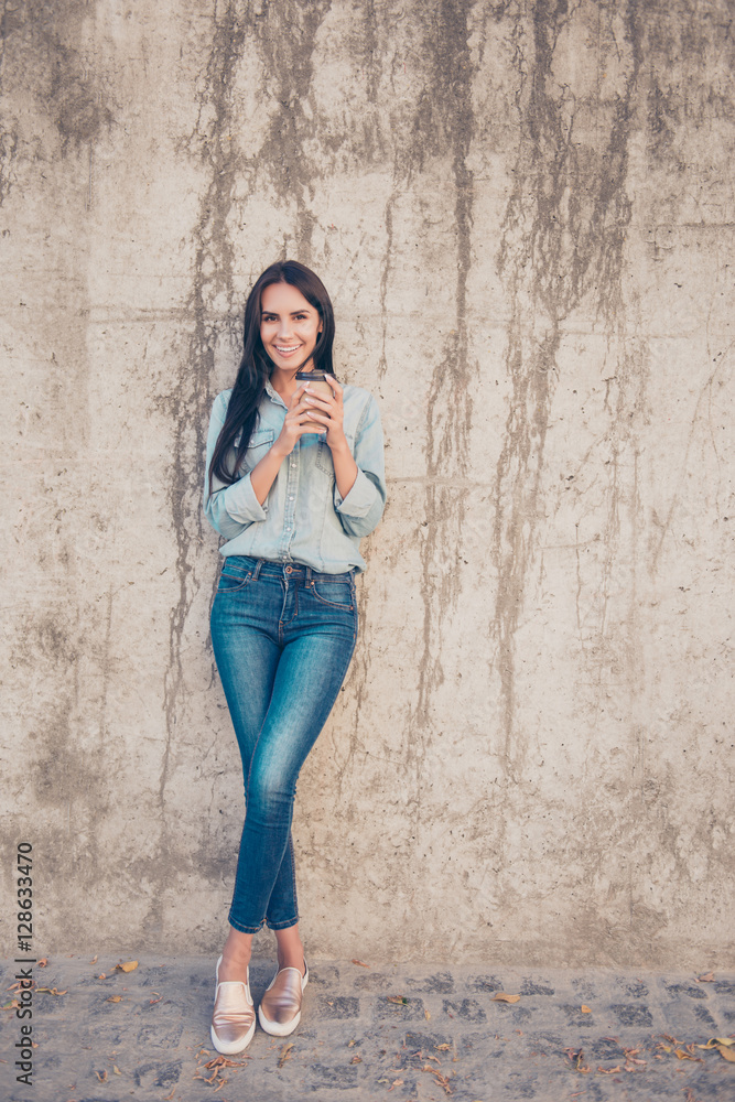 Full photo of pretty woman drinking coffee near stone wall Full photo of pretty woman drinking coffee near stone wall