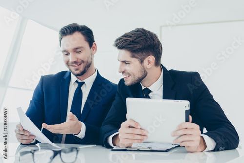 Bilde på lerret Two young businessmen discussing  financial growth of their comp