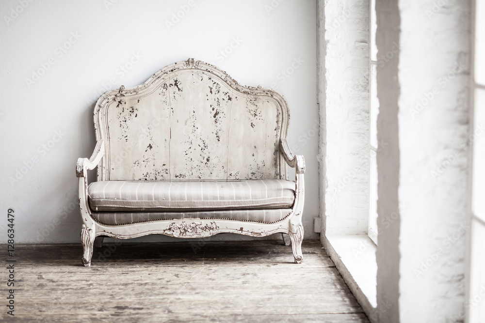 White textile classical style sofa in vintage room. White old ba