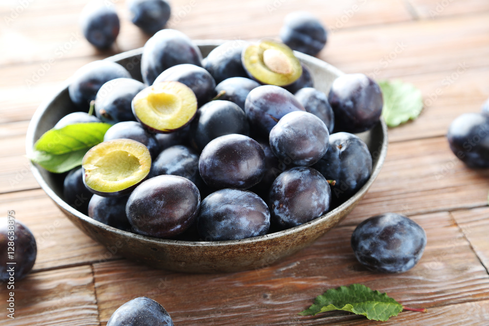 Tasty and ripe plums on brown wooden table Tasty and ripe plums on brown wooden table