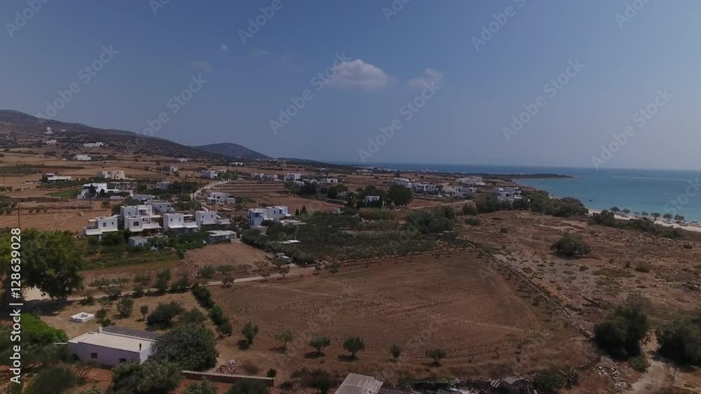 Aerial of backlands with scattered houses over Greek island village of Aliki, Paros. Aerial of backlands with scattered houses over Greek island village of Aliki, Paros.
