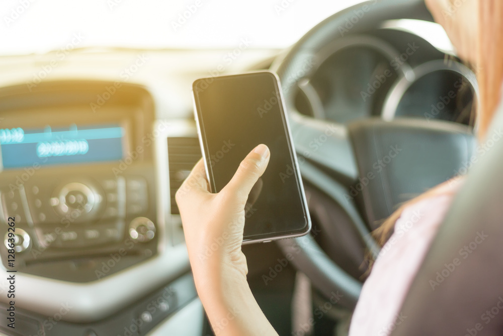 Asian women are driving cars and using a smartphone on the road.
