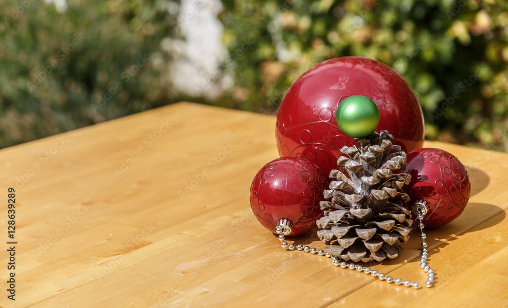 Christmas balls next to pinecone on wooden table Christmas balls next to pinecone on wooden table