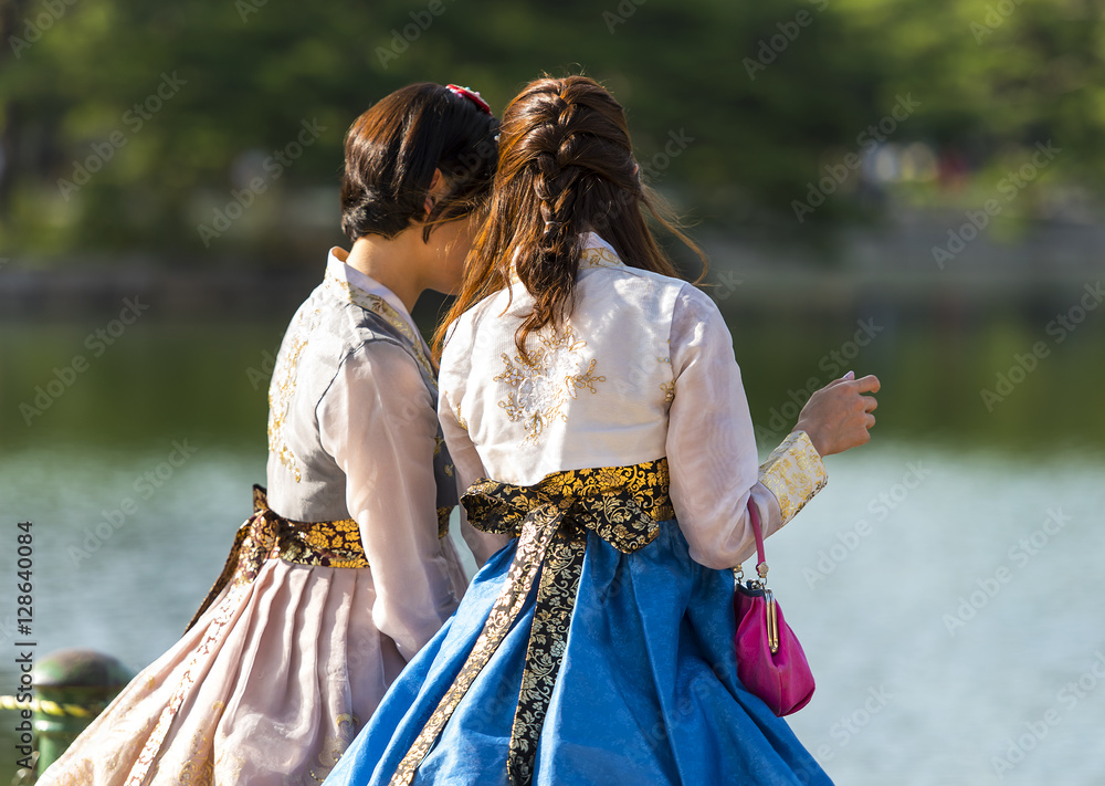 Fototapeta premium Dwa koreański dziewczyna ubrana w stary tradycyjny strój rozmawia nad jeziorem w parku