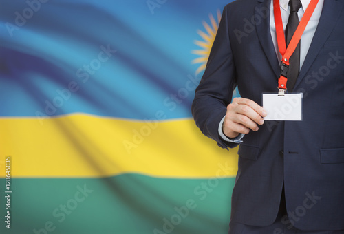 Businessman holding name card badge on a lanyard with a national flag on background - Rwanda