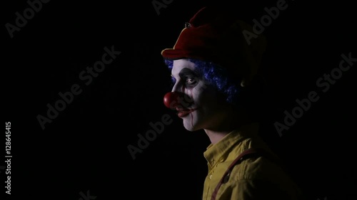 Scary Clown threateningly looking into camera. HD. photo