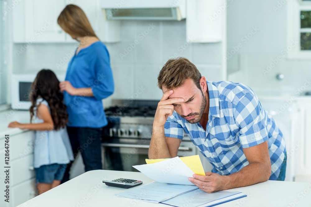 Obraz premium Worried father looking at bills at home