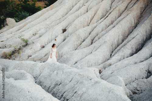 beautiful bride in a white dress walking on sand quarry © jujik