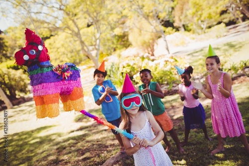 Little girl is going to broke the pinata for their birthday photo