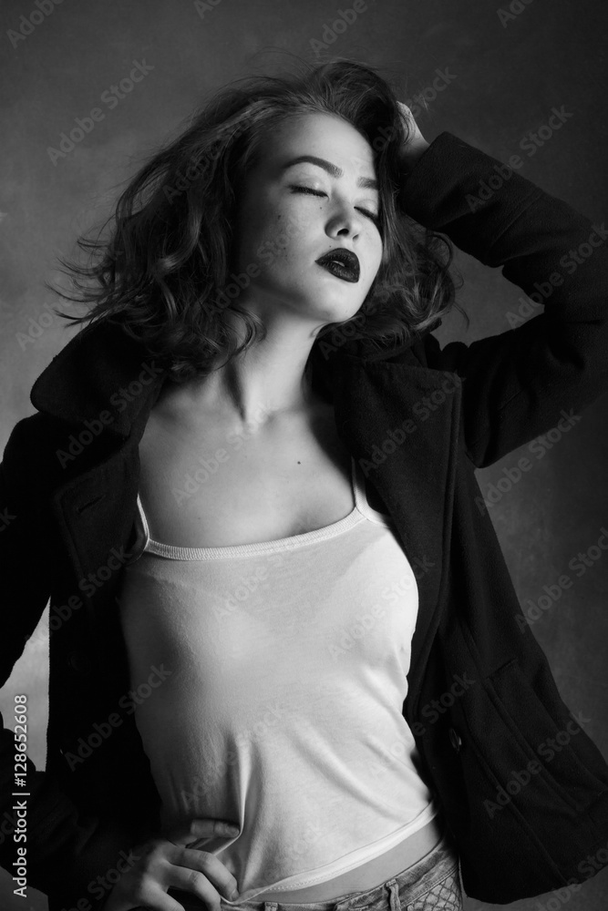 sensual young woman posing on black background, monochrome