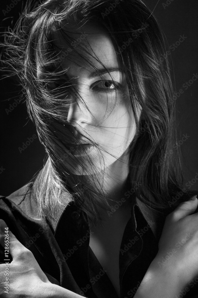 sad woman with blowing hair on black background, monochrome sad woman with blowing hair on black background, monochrome
