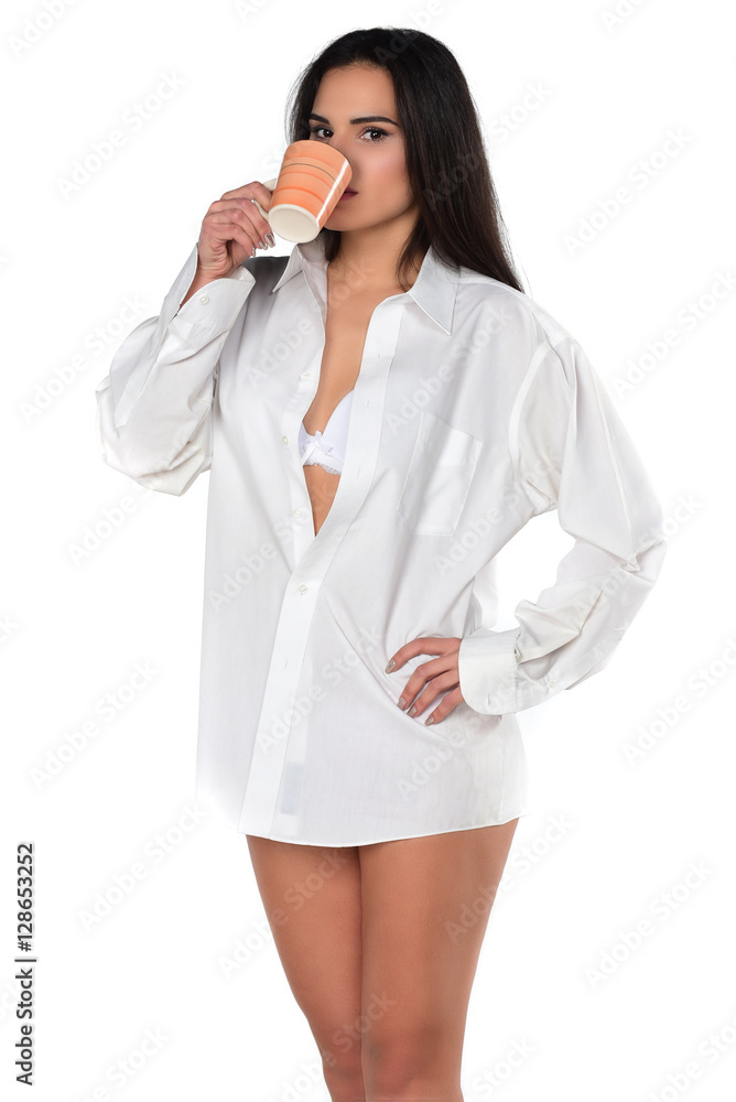 pretty smiling brunette in a white men's shirt holding cup of coffee pretty smiling brunette in a white men's shirt holding cup of coffee