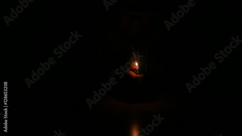 Men's hand lights a cigarette lighter in the dark