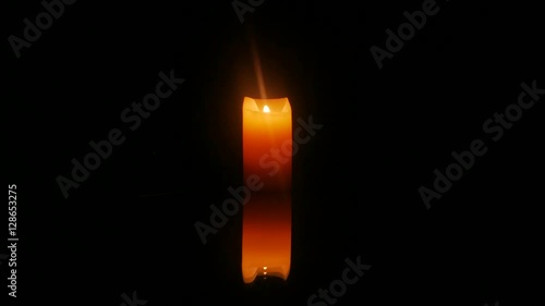 Burning candle reflected on the mirror surface