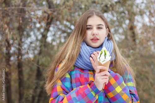 Beautiful girl on the nature in the winter outside with ice cream 