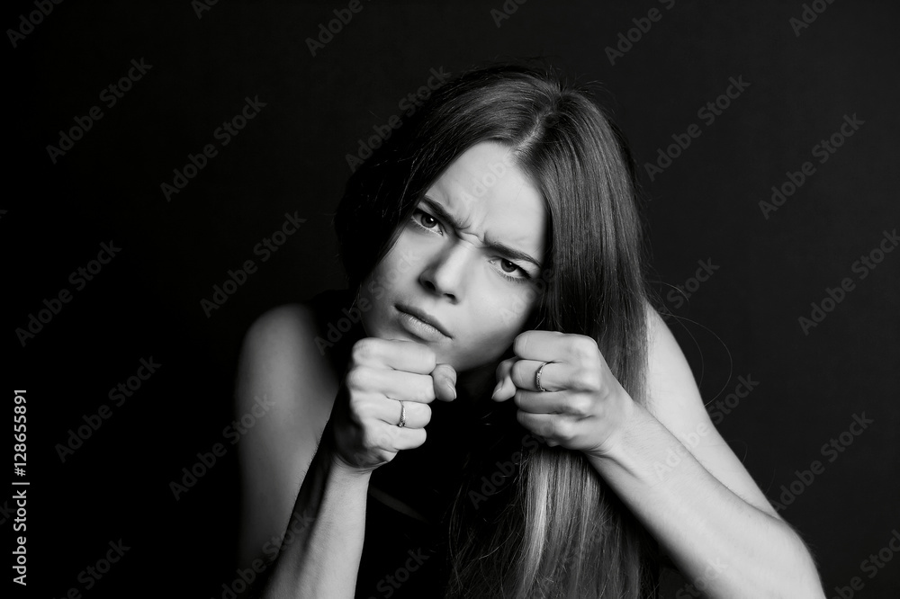 Hostile posture. Clenched fists before her face. Young beautiful girl with long hair Hostile posture. Clenched fists before her face. Young beautiful girl with long hair