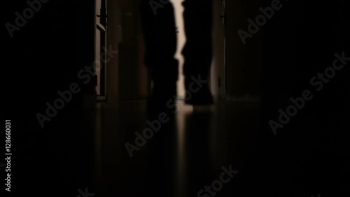 a man walks down the dark corridor