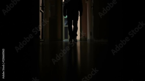 a man walks down the dark corridor