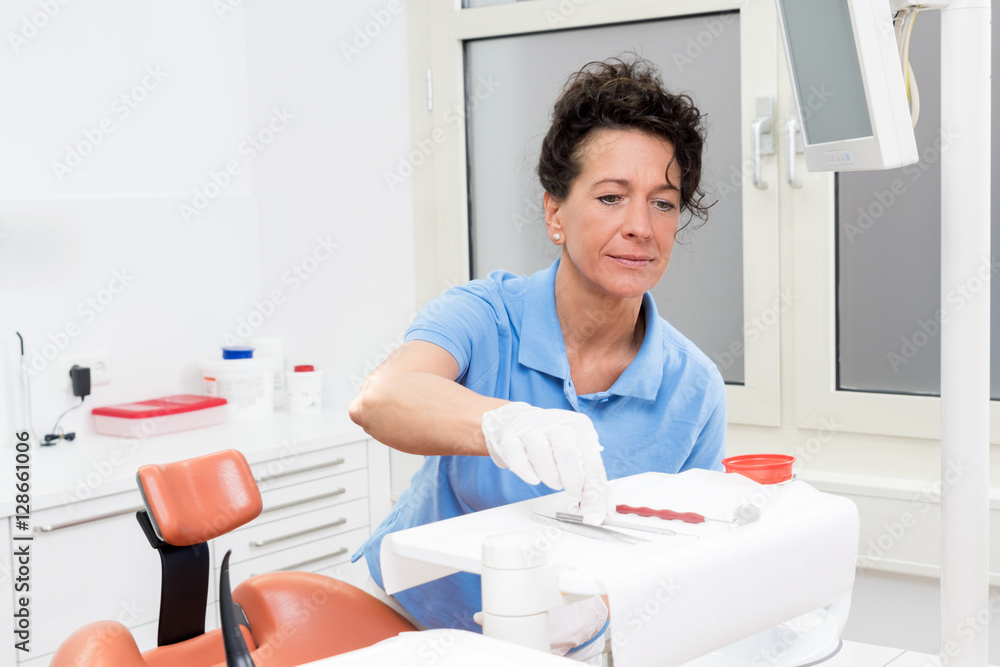 Zahnmedizinische Assistentin beim vorbereiten des Behandlungsrau