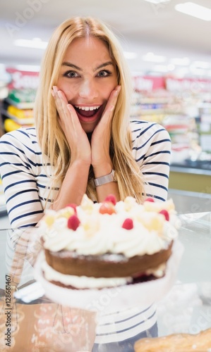Happy woman with mouth open in front of cake