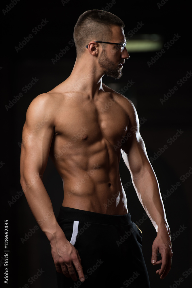 Muscular Geek Man Flexing Muscles In Gym