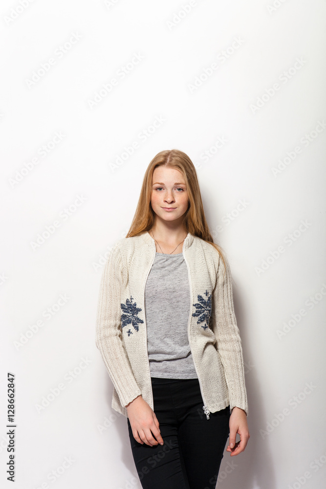 Human face expressions and emotions. Young adorable redhead woman in cozy shirt hands behind head with gorgeous red hair having fun against white studio wall Human face expressions and emotions. Young adorable redhead woman in cozy shirt hands behind head with gorgeous red hair having fun against white studio wall