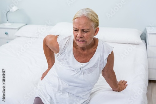 Quadro su tela Senior woman suffering from back pain at home