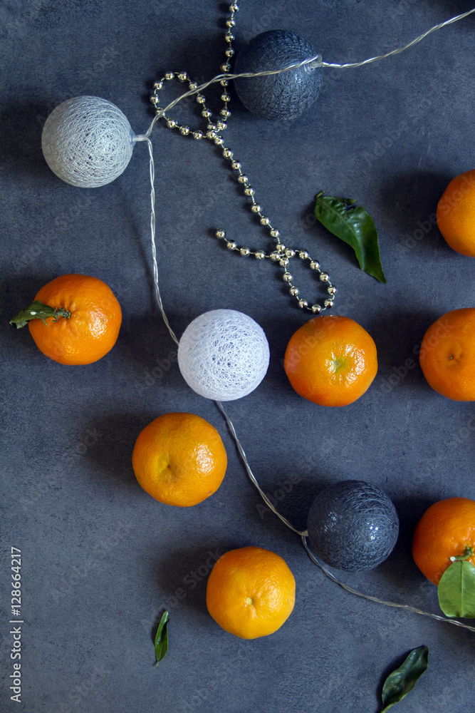 Tangerines, clementines and cottton balls. Gray background. Tangerines, clementines and cottton balls. Gray background.